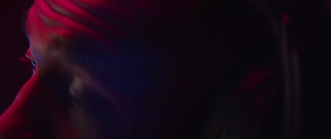 Man wearing headset in room lit by colored lighting listens