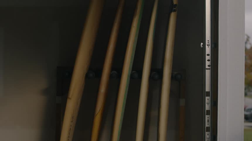 Surfboards hang vertically on the wall in a garage