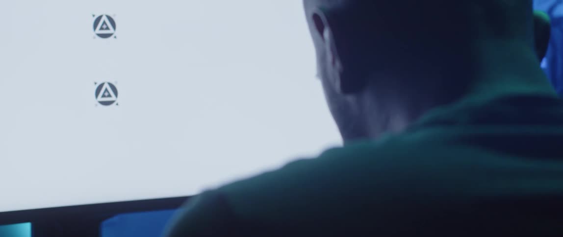 A man rubs the side of his head while sitting in front of his computer