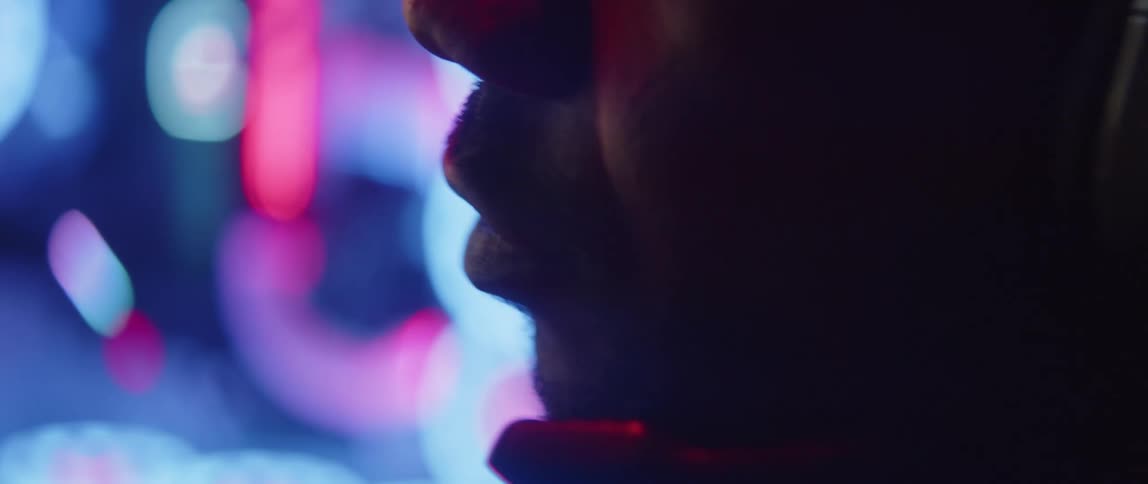 Man with headphones sits near pc case speaking into microphone