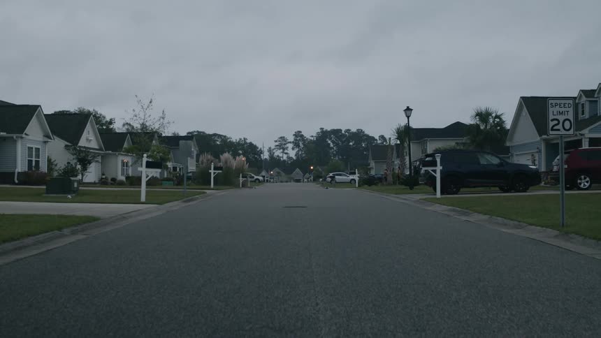 Road in the residential neighborhood with houses on cloudy day
