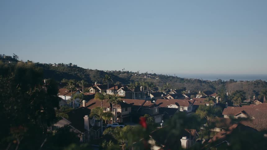 View of the rooftops of houses on a small cozy neighborhood on the hills at morning