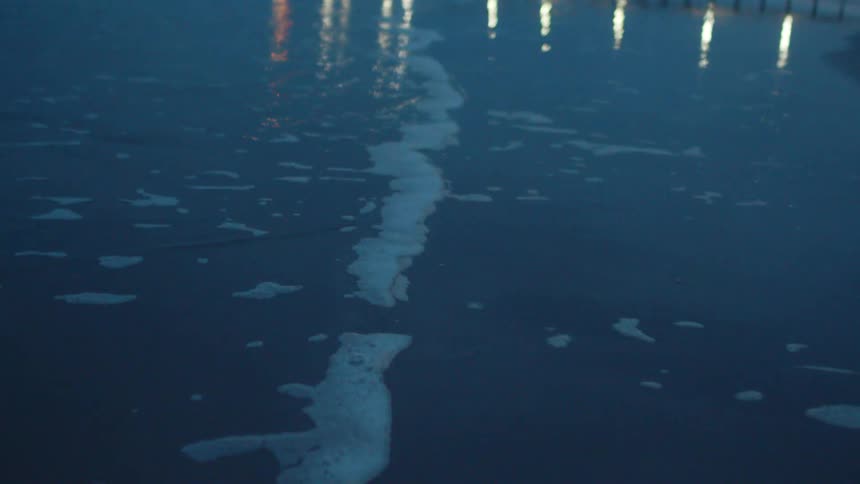 A wave slowly washes into the beach during the evening