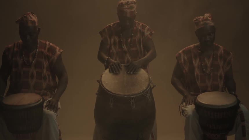 Three people are holding drums together