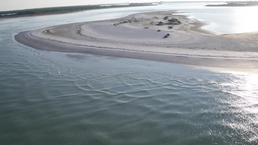 Sand dunes line this shore on a cloudy day