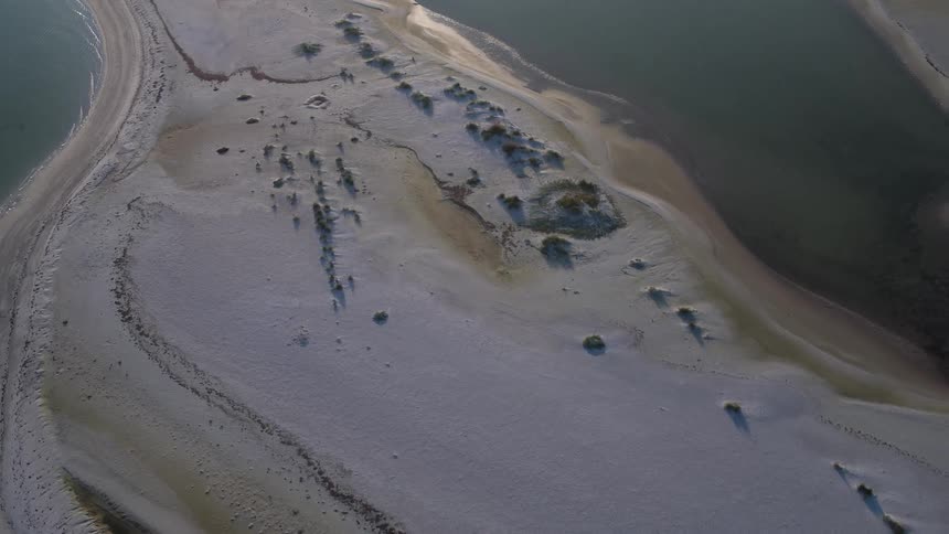 A small island is covered with snow and sand