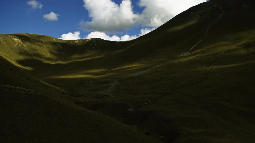 The mountains are green and tussock clad and covered in shade
