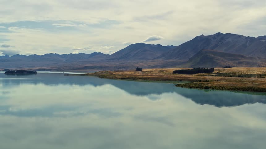 Clouds are reflecting the mountain lake during the daytime