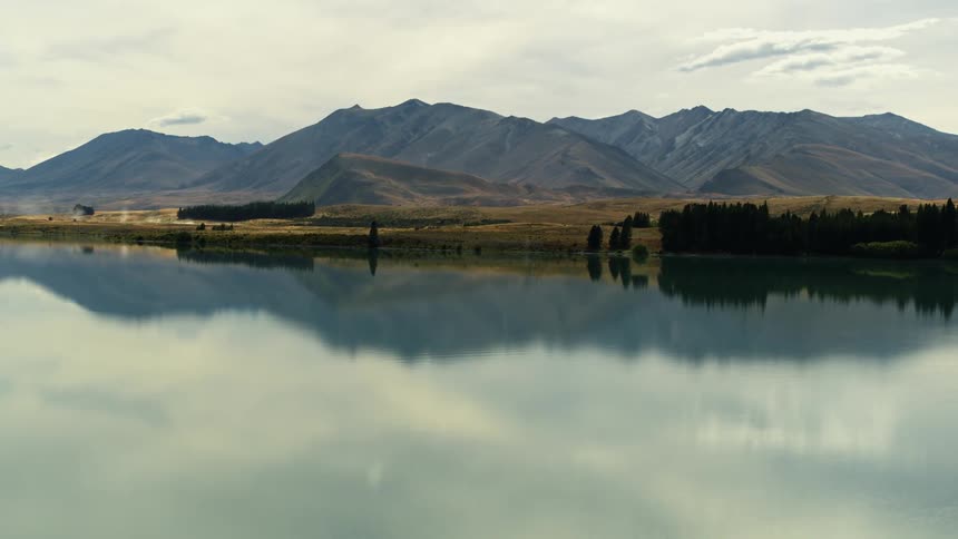 Aerial view of still lake and distant mountain range