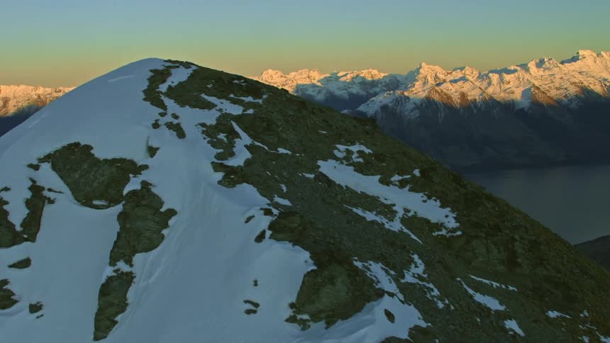 Aerial view of the mountains reveal alpine lake during dusk
