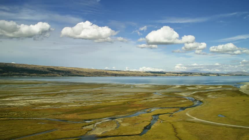 Aerial view of a flat landscape near water is displayed