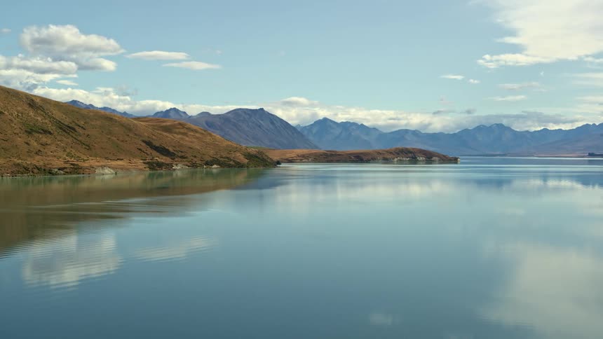 A blue lake reflects the mountains aerial in iconic New Zealand