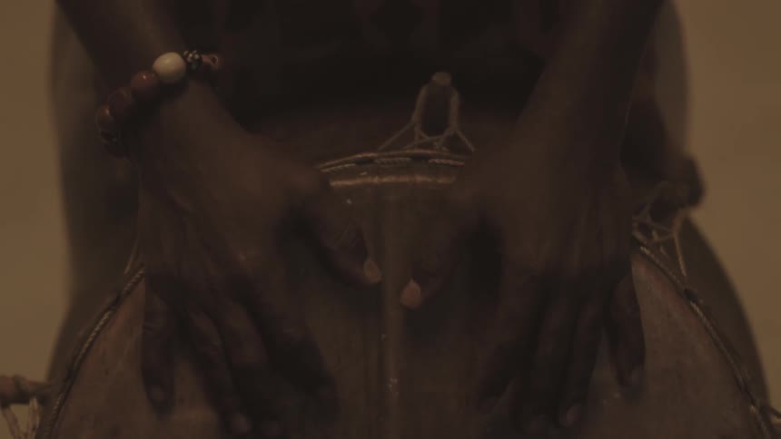 A man resting his hands on a bongo