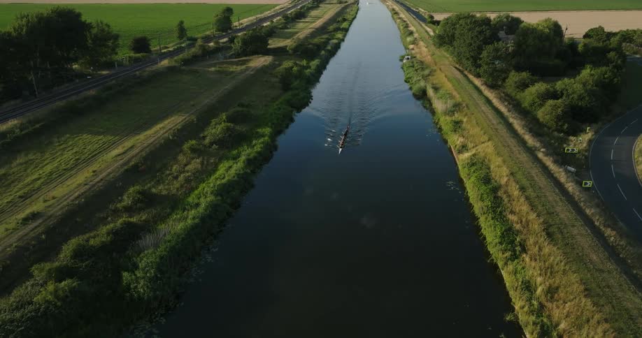 A rowing team paddles together down a river