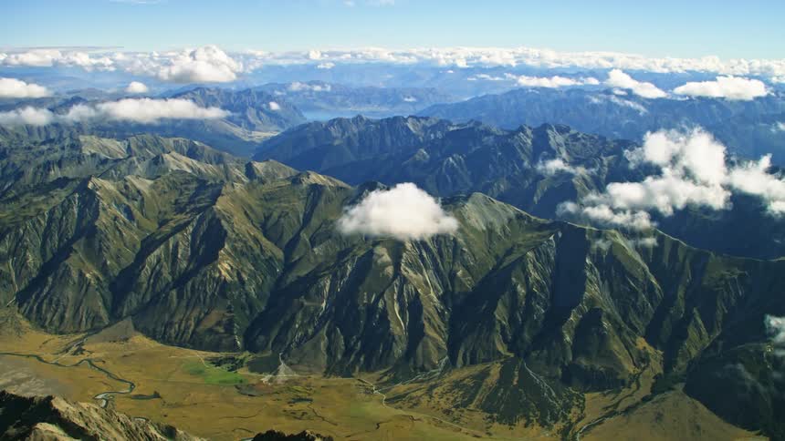 An aerial view of clouds floating above a mountain range