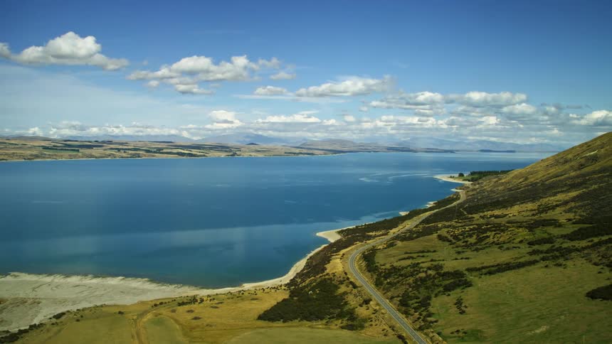 A lake and hills in nature with winding road