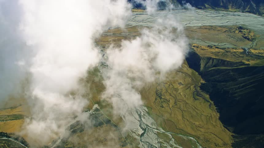 Traveling above the clouds looking down on mountain and stream