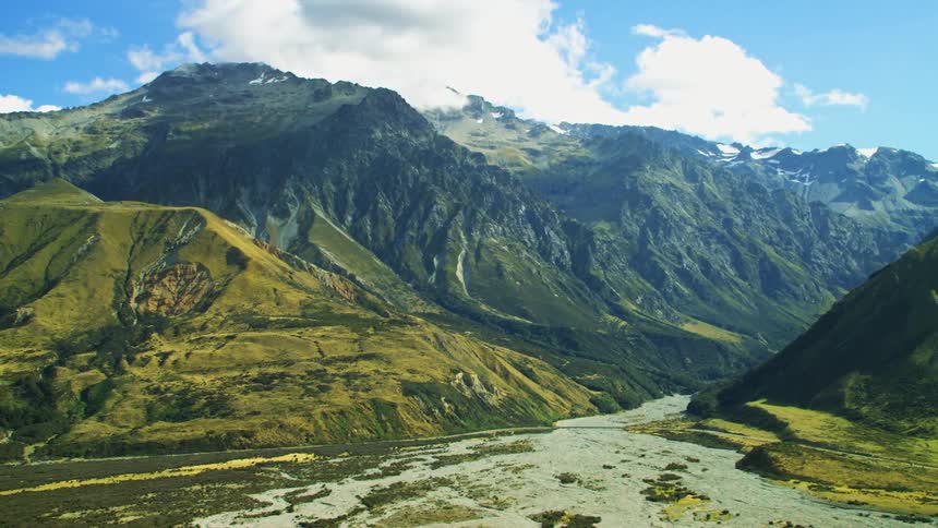 The mountains are covered in green and brown grasses
