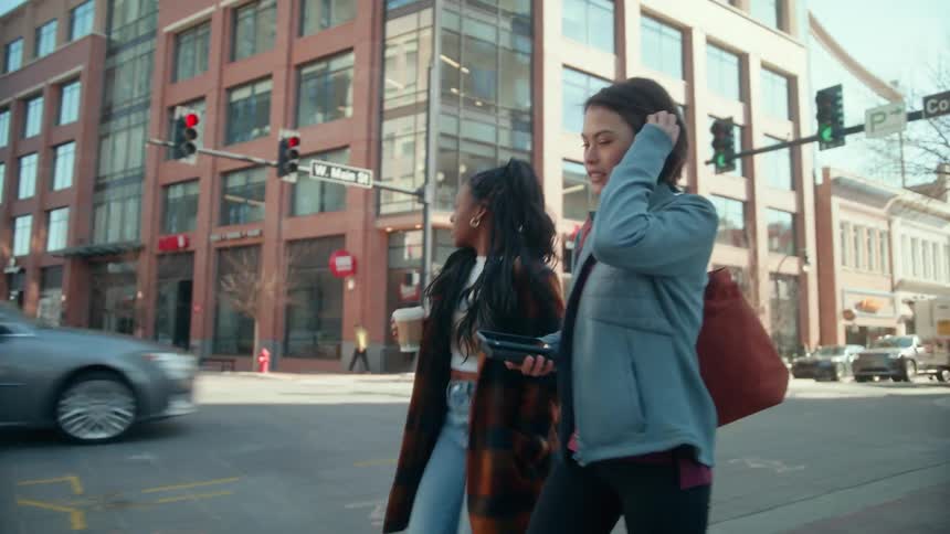 Two young friends walking on the city streets early at morning
