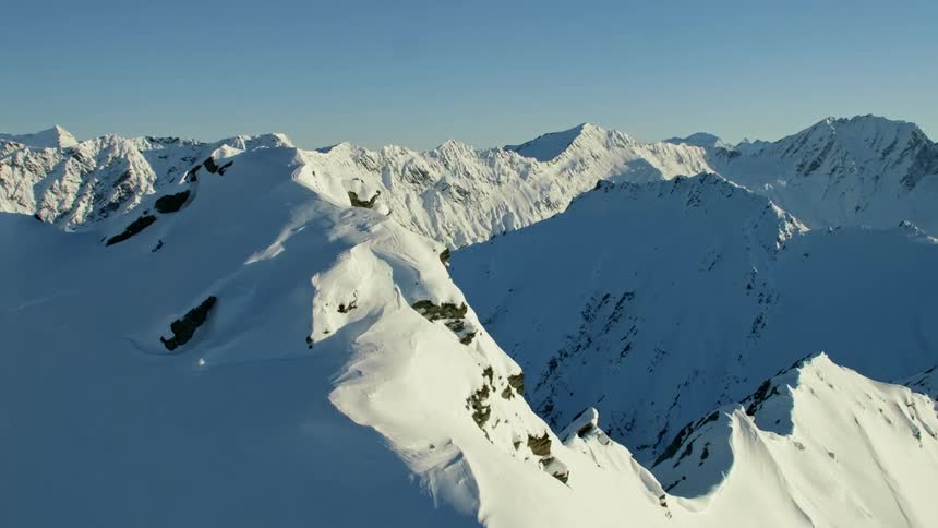 Aerial view of snowy mountain range ridges and slopes