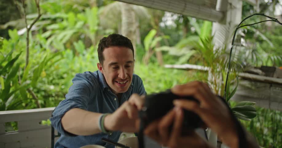 A man and woman using a laptop outdoors