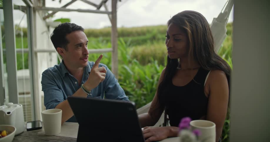 A man and woman talking using a laptop