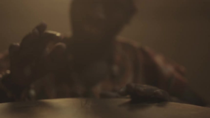 A man playing a bongo in a dimly lit area