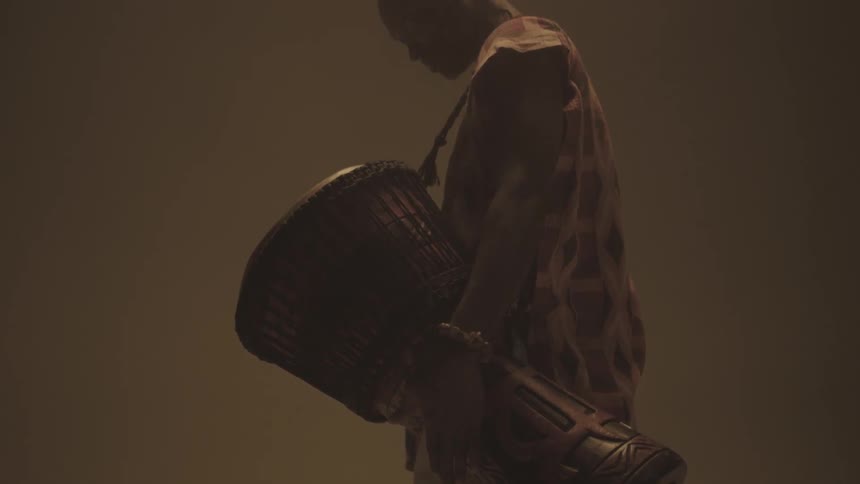 A man is carrying a large drum