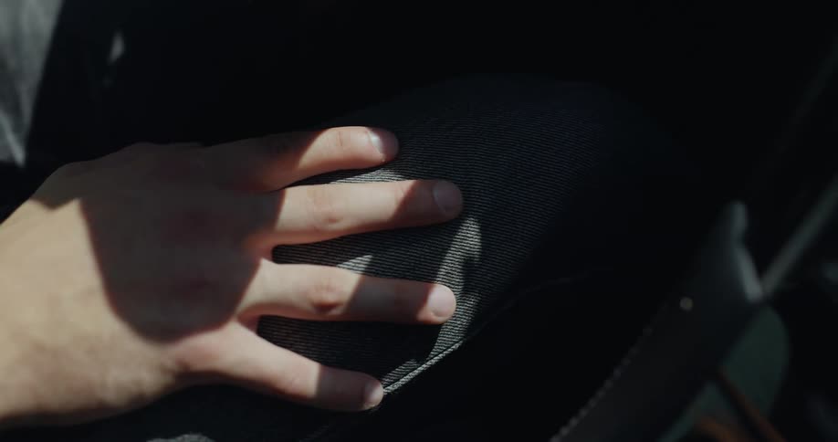 A person resting their hand on their thigh