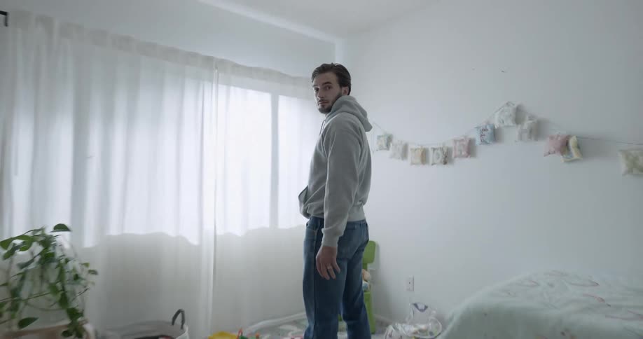 A man is standing in a kids bedroom and looking around