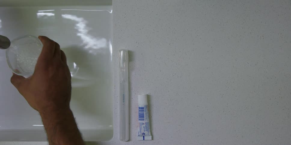 A person fills a glass with water