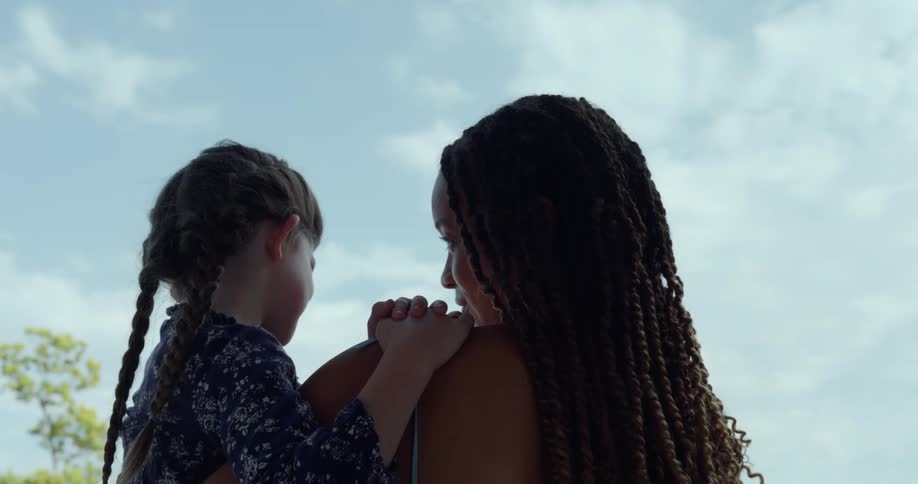 A woman is holding a child outside