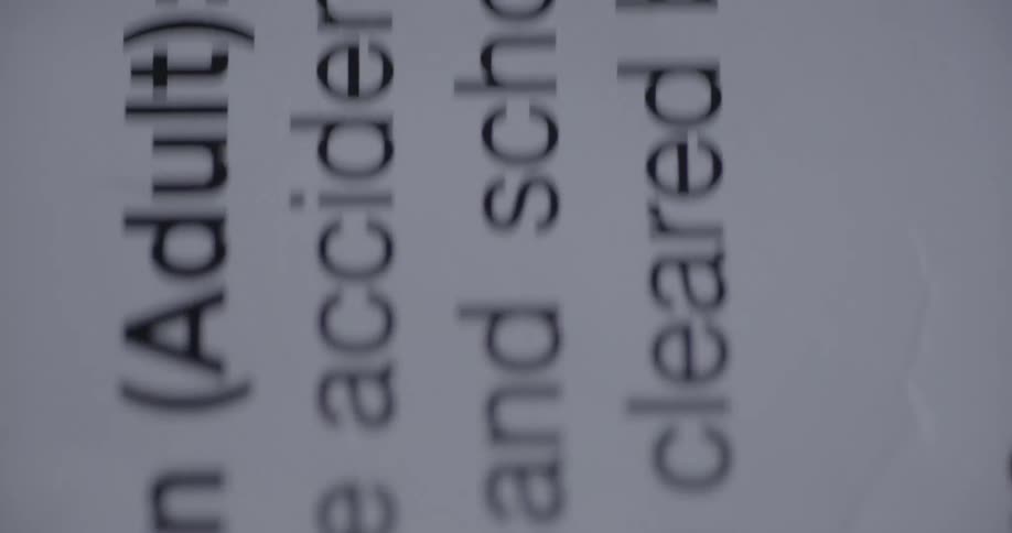 Extreme close up of text printed on white paper panning up