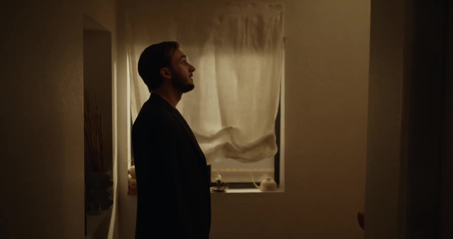 Man with beard and blazer jacket and pants follows woman with dreadlocks and dress going upstairs arguing with each other