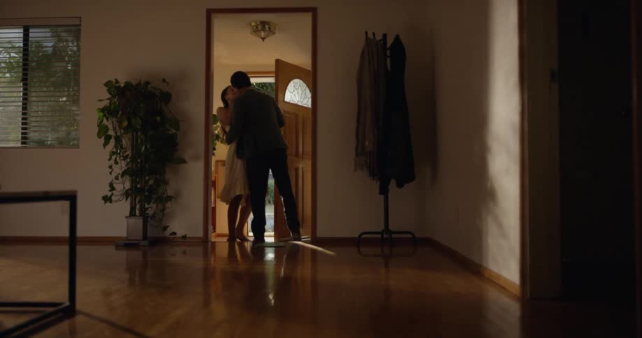 A couple enter the home and kiss