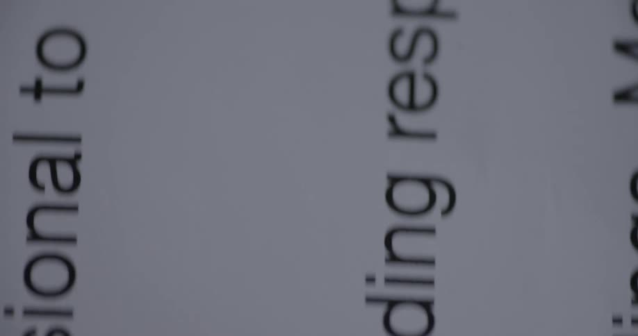 Close up of the text on pages of white paper panning up