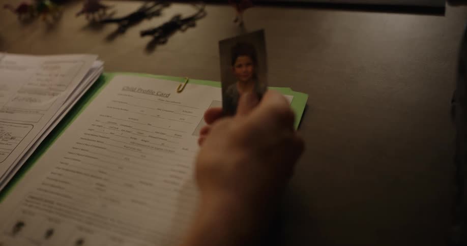 A person lifts a photo form the folder