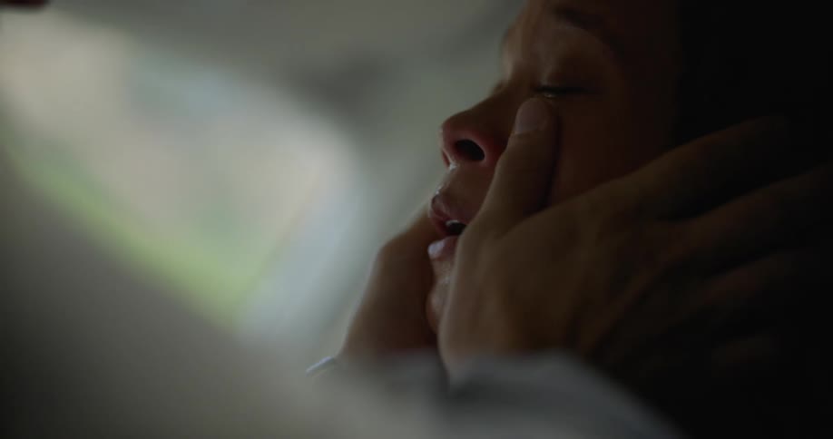 A woman is crying and a man kisses her