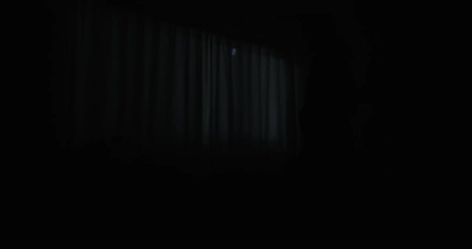A man turns around as a bright light passes by the window