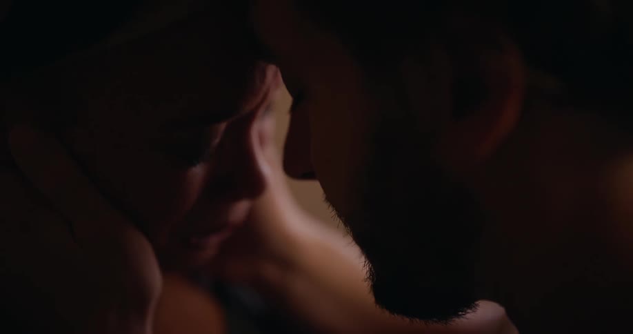 A man holds a womans face and talks to her as she cries