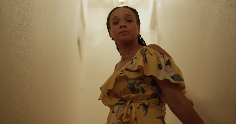A woman turns on the stairs and talks