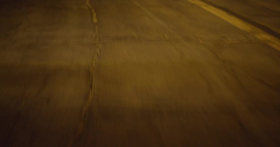 Traveling on an old road at night with cracks in the asphalt