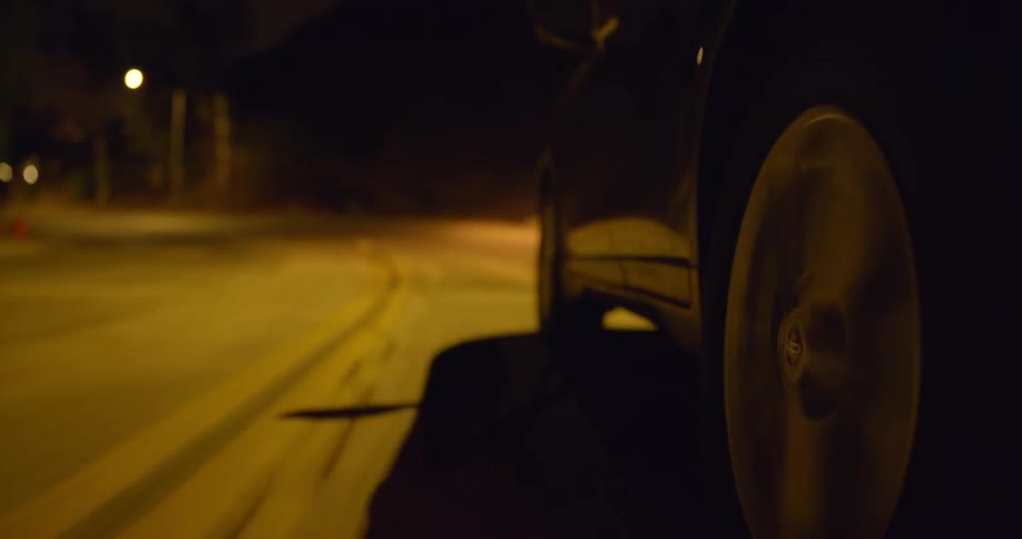 Car driving on highway takes a bend at night