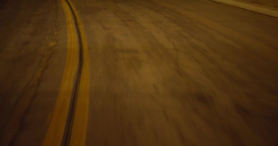 Traveling on a road at night with cracks in the asphalt