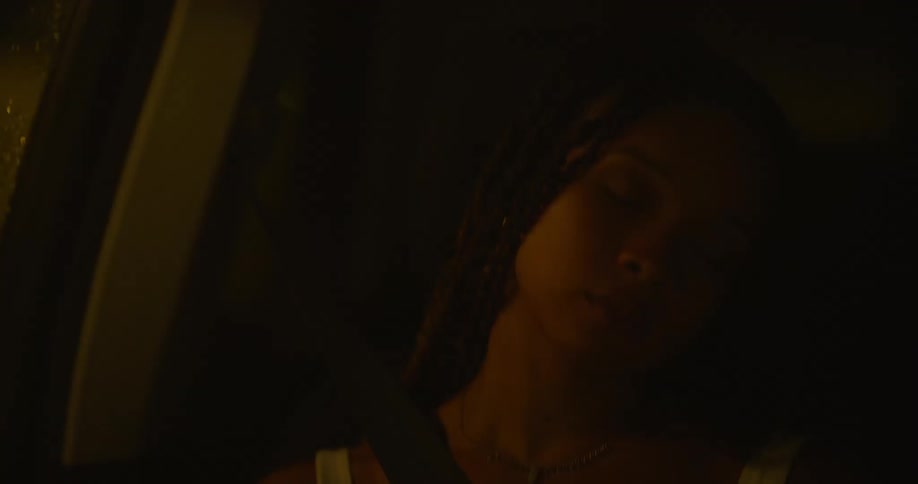 A teenage girl is sleeping in the passenger seat of an automobile as it travels on a street