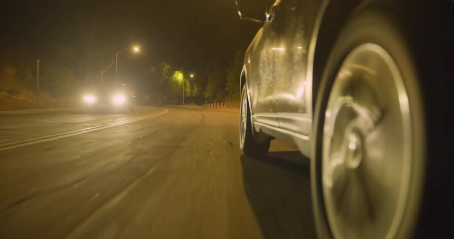 A car travels along a road at night