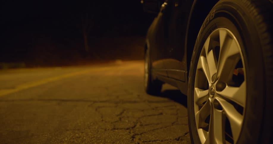 A car driving on a cracked road at night