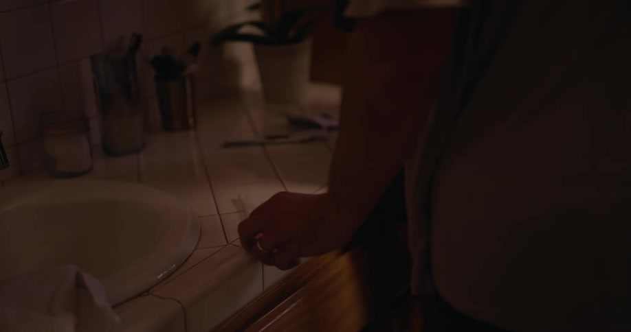 A man hugs a crying woman in the bathroom