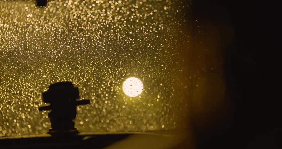 A person is driving on a rainy night