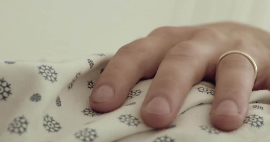 Close up of the hand of a person resting over the chest while tapping a finger